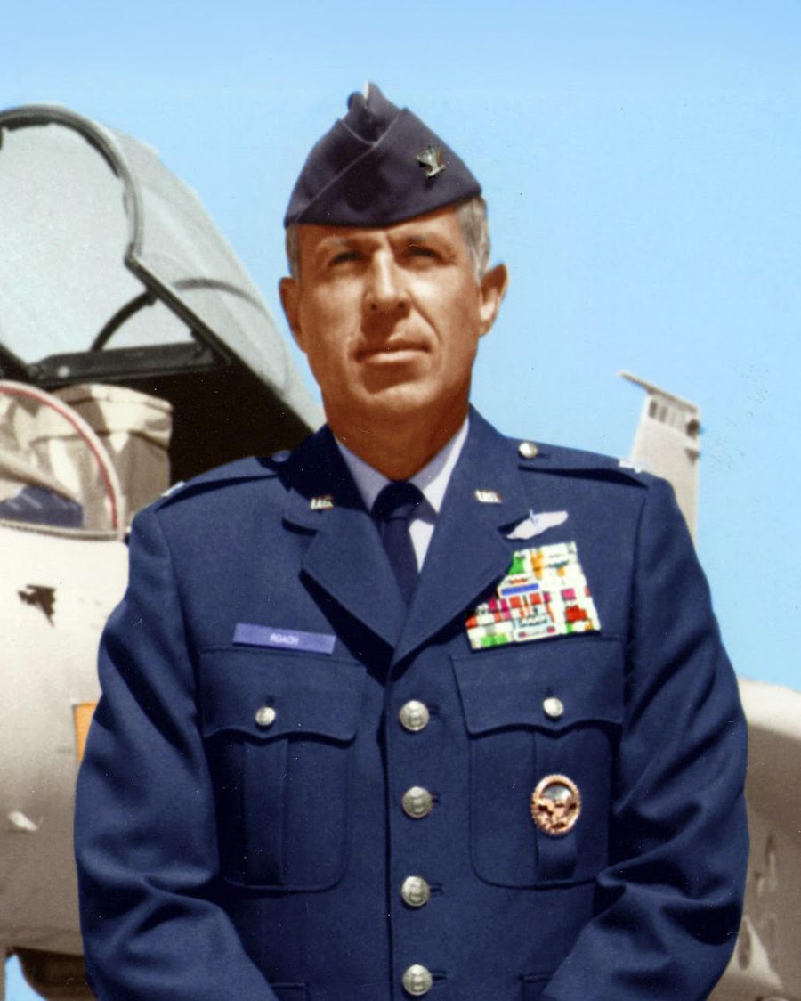 Colonel Douglas C. Roach in Air Force service dress in front of a fighter aircraft.